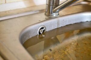 Standing water in a kitchen sink caused by a clogged drain